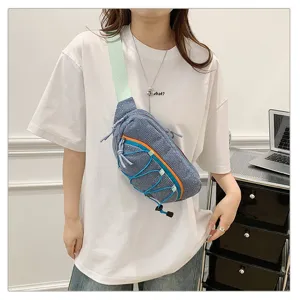 Blue corduroy sporty chest bag worn crossbody style on a model in a white t-shirt