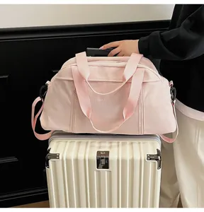 Stylish pink travel duffel bag for sports and yoga conveniently placed on a white suitcase
