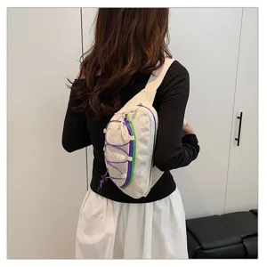 Back view of a white sporty chest bag with colorful bungee cords worn by a model.