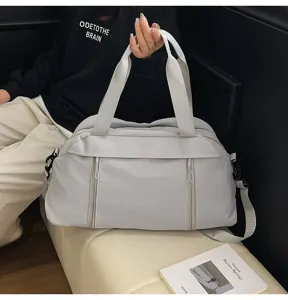 Grey nylon fitness travel bag shown held by a model in a lifestyle setting