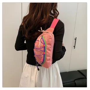 Back view detail of woman wearing pink corduroy chest bag with colorful neon cord accents