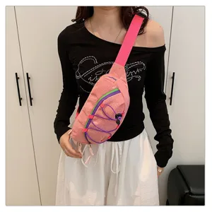 Pink corduroy sporty crossbody fanny pack shown worn by a model in a clean indoor setting.