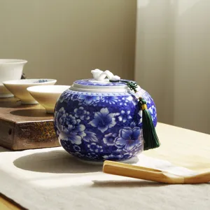 Elegant traditional blue and white porcelain tea canister with floral pattern and tassel decoration