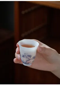 Dettaglio di una delicata tazzina da tè in ceramica bianca con pittura tradizionale