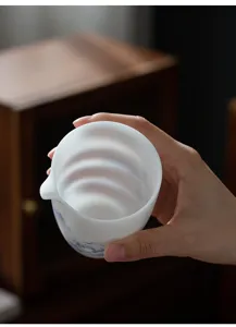 Dettaglio di una tazza da tè in ceramica bianca opaca fatta a mano con motivi blu