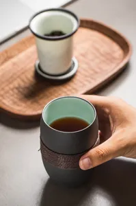 Macro view of matte ceramic tea cup with woven heat-insulating wrap