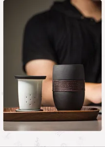 Detail view of matte ceramic tea mug with separate ceramic filter and wooden tray.