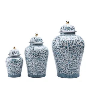 Set aus drei blau-weißen floralen Deckelvasen mit goldenen Knöpfen für die Heimdekoration.