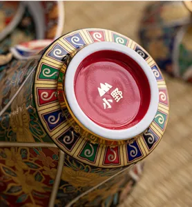 Vista macro detallada del fondo de la taza de té gaiwan de esmalte dorado con el logotipo