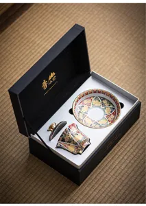 Elegante juego de té de esmalte con detalles dorados en caja de regalo negra de lujo