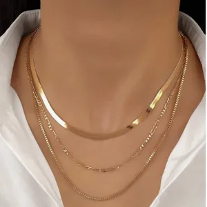 Detailed view of gold-layered necklace set including snake, Figaro, and box chain styles