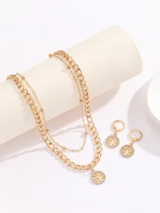 Detailed view of the gold-tone double layer necklace and matching tree pendant earrings set.