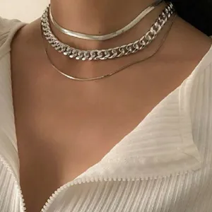 Detailed macro view of silver punk chunky chain and snake bone layered necklace set