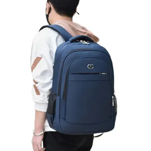 Large blue casual backpack for travel and school worn by a male model on white background