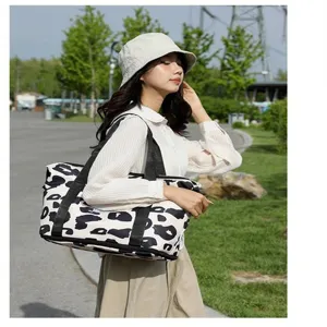 Outdoor lifestyle weergave van een grote reistas met een stijlvolle zwart-witte koeienprint
