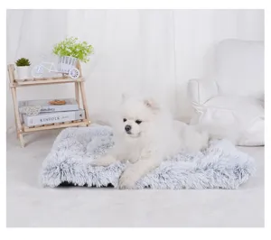 White Pomeranian dog resting on a cozy light gray long-plush pet mat in a bright room