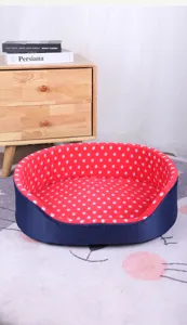 Cozy red polka-dot interior pet bed for cats and small dogs shown in a home setting
