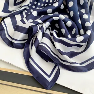 Primo piano di sciarpa in seta vintage blu e bianca a pois e strisce elegante