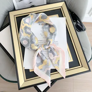 Dettaglio macro di una sciarpa in seta vintage floreale su cornice decorativa d'oro