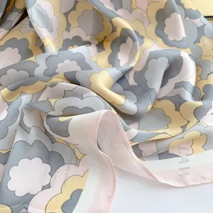 Dettaglio macro del motivo floreale retrò sulla trama elegante del foulard in seta