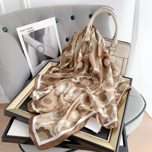 Vista dettagliata di un foulard in seta retrò a fiori su una borsa beige elegante