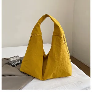 Detailansicht einer leuchtend gelben, großen Nylon-Hobo-Tragetasche für Damen.