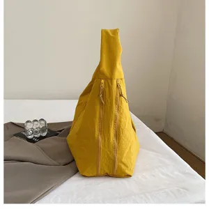 Detailansicht einer gelben wasserdichten Nylon-Hobo-Tasche mit doppelten Reißverschlusstaschen