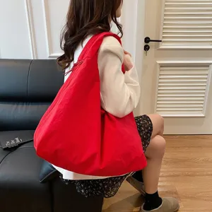 Seitenansicht einer großen roten Nylon-Tragetasche, getragen von einem Modell