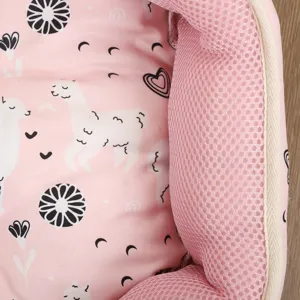 Close-up detail of a pink breathable pet bed with cute white alpaca and heart print patterns.