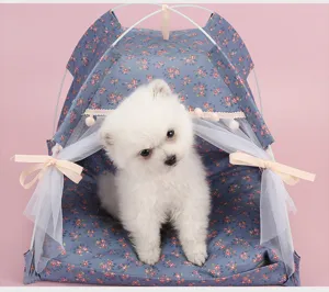 Detailed macro view of a blue floral print pet tent with a cute white puppy inside
