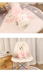 Close-up of a white dog wearing pink cartoon rabbit flannel pajamas in a cozy home setting.