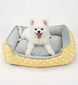 Vista dettagliata di una cuccia gialla a pois con un morbido cuscino di peluche grigio