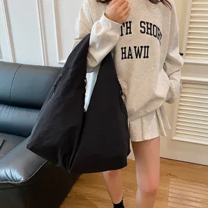 Große schwarze wasserdichte Nylon-Hobo-Tasche, an einem weiblichen Model für den Alltag gezeigt.