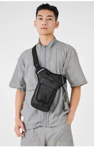 Detailed view of the black waterproof tactical leg bag worn by a male model in grey