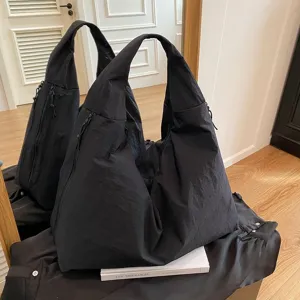 Borsa hobo oversize in nylon nero minimalista con finitura impermeabile e zip
