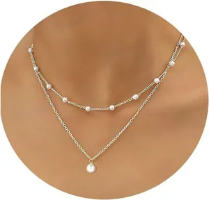 Detailed view of French double-layered gold chain necklace with delicate white pearls