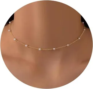 Close-up of elegant gold pearl necklace on model's neck for a French minimalist look.