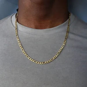 Detailed view of classic men's gold Figaro chain necklace worn over a grey T-shirt