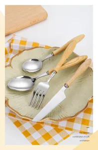 Detail view of 304 stainless steel cutlery set with elegant ash wood handles on a ceramic plate