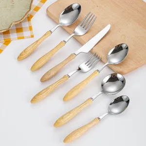 Premium 304 stainless steel cutlery set with ash wood grain handles displayed on a board