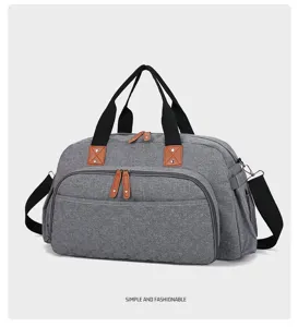 Détail de sac de voyage gris, tissu résistant, poignées noires, accents en cuir marron.
