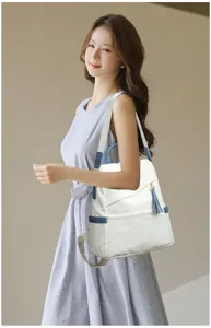 Elegant white anti-theft backpack with blue trim carried by a model outdoors