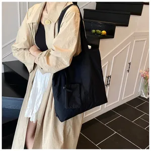 Femme asiatique portant un grand sac cabas noir minimaliste pour le quotidien