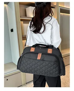 Vue détaillée du sac de voyage matelassé gris foncé avec bandoulière fonctionnelle et poches.