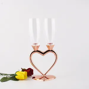 Close-up of heart-shaped champagne flutes with rose gold metal stand for weddings