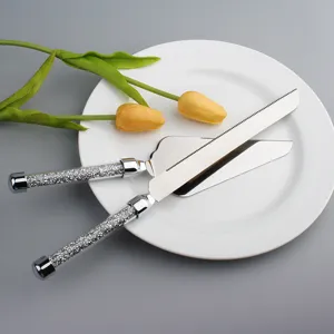 Detalle del juego de cuchillo y pala para tarta en acero con mangos de cristal