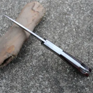 Close-up showing the durable metal spine and wood handle of the folding pocket knife.