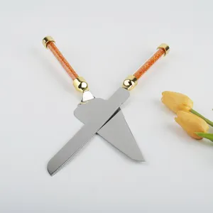 Primer plano de juego de pala y cuchillo para tartas con mangos de cristal naranja