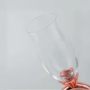 Close-up of elegant crystal champagne glass with a rose gold heart-shaped base detail