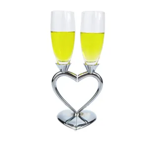 Close-up of elegant heart-shaped champagne flute set with polished silver finish stems.